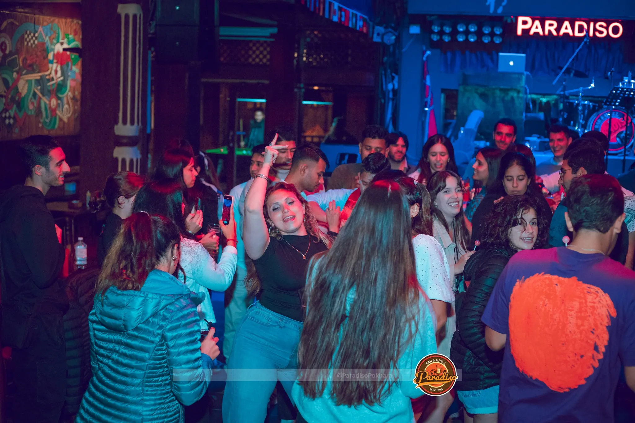 Guests dancing in front of the stage under the Paradiso sign