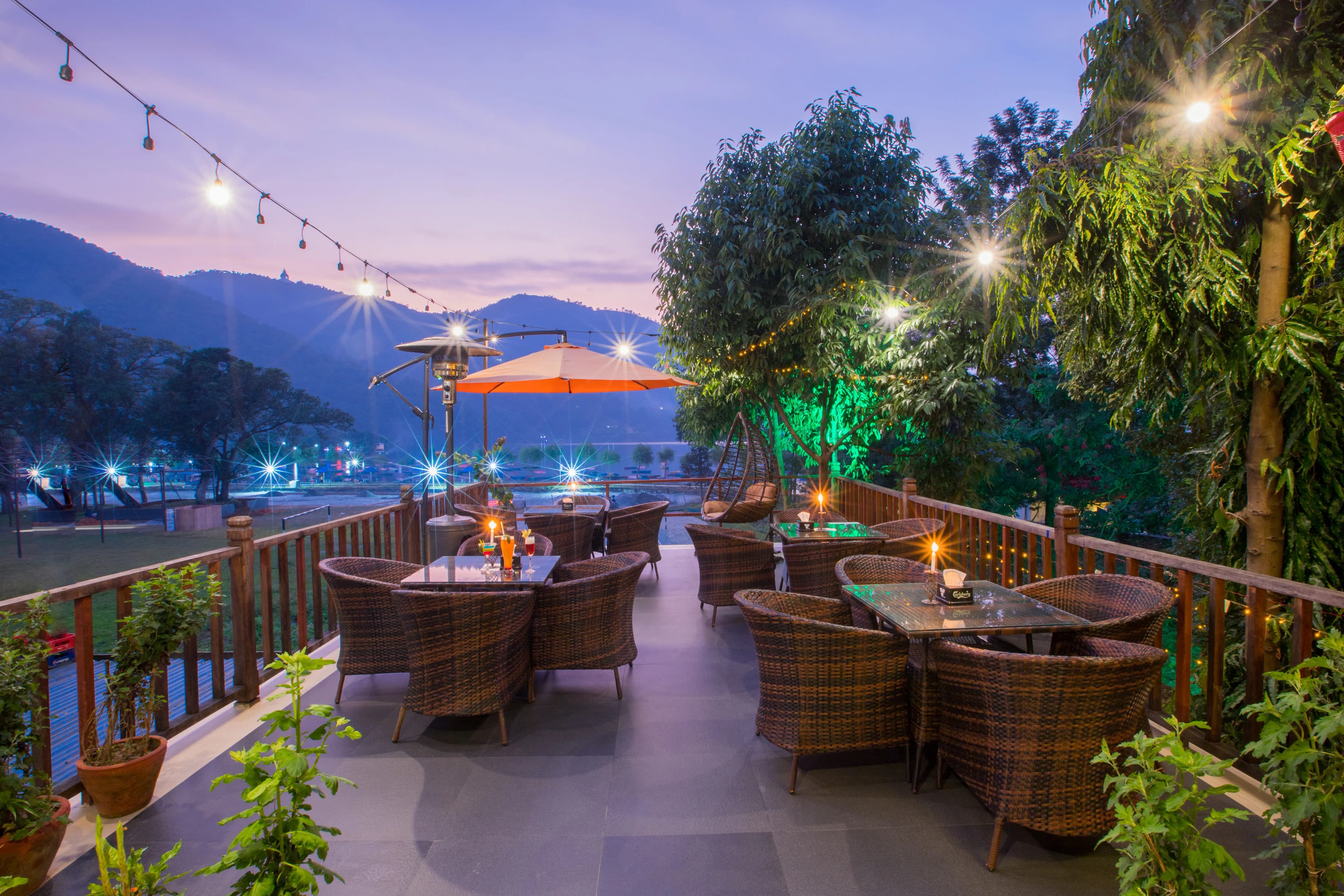 The terrace at dusk, string lights and the lake beyond